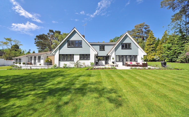 white and gray wood paneled house near grassy field