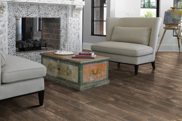 dark stained wood look tile flooring in an elegant living room with a stone fireplace